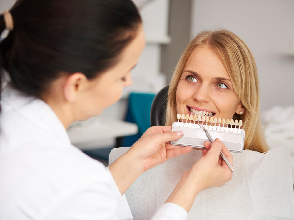 woman at dental appointment having her teeth shade matched