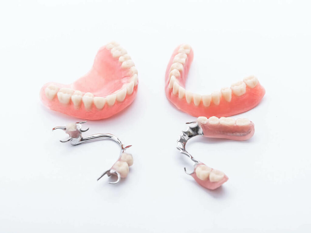 Full and partial dentures and temporary bridges on white background