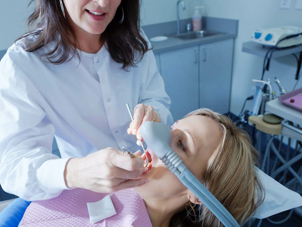Doctor conducting procedure on patient under dental sedation