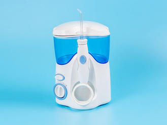A water flosser with a white and blue color scheme, featuring a transparent water reservoir and a control dial.