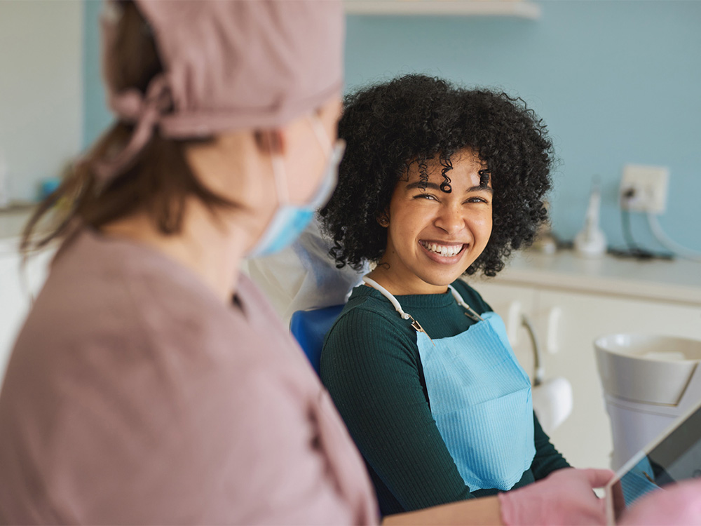 Patient speaking to dental hygienist during dental exam